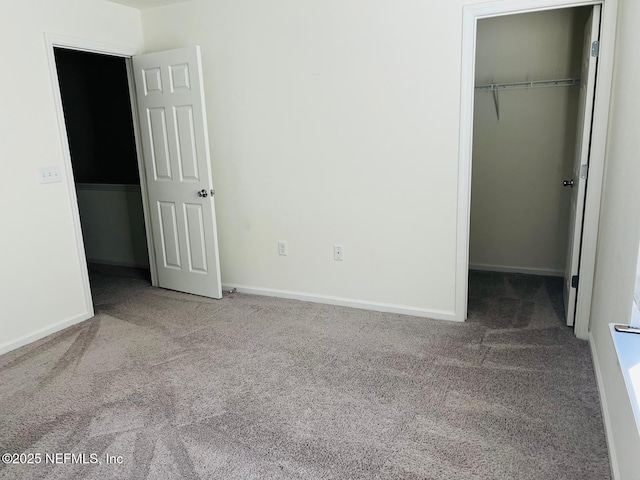 unfurnished bedroom featuring light carpet, a closet, and a spacious closet