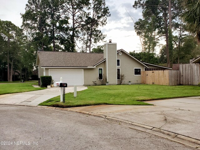 ranch-style home featuring a garage and a front lawn