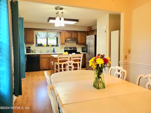 dining room with light wood-type flooring and sink