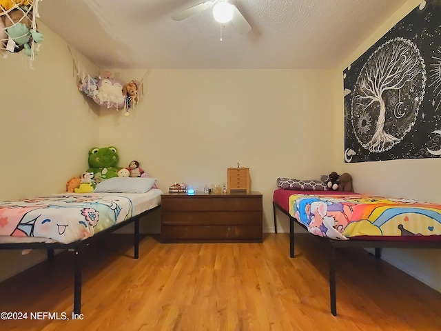 bedroom featuring ceiling fan, a textured ceiling, and light hardwood / wood-style flooring