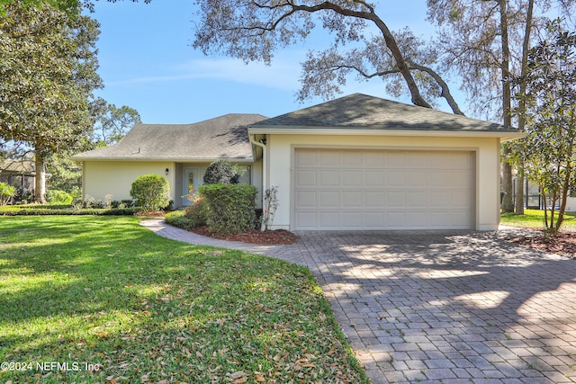 single story home featuring a front yard and a garage