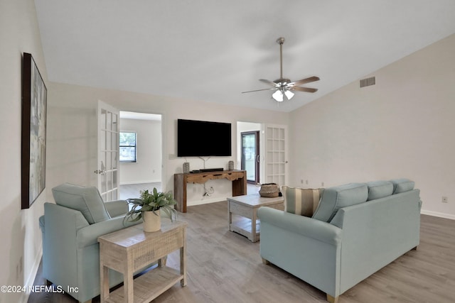 living room featuring vaulted ceiling, ceiling fan, french doors, and light hardwood / wood-style flooring