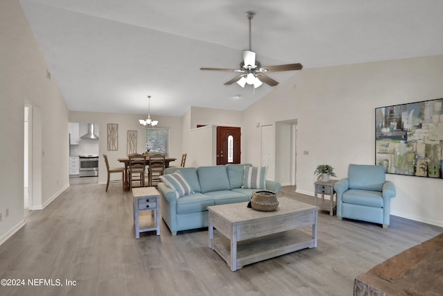 living room featuring ceiling fan with notable chandelier, light hardwood / wood-style floors, and high vaulted ceiling