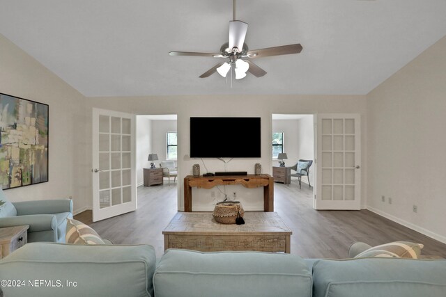 living room with ceiling fan, french doors, vaulted ceiling, and wood-type flooring