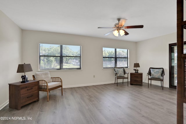 living area featuring a wealth of natural light, ceiling fan, and light wood-type flooring