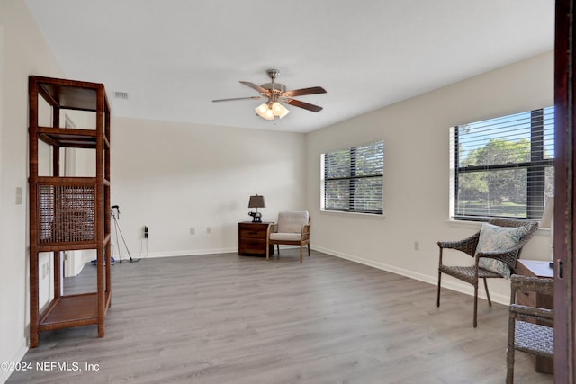 living area with light wood-type flooring and ceiling fan