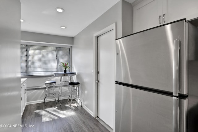 kitchen with stainless steel fridge, dark wood-type flooring, and white cabinets