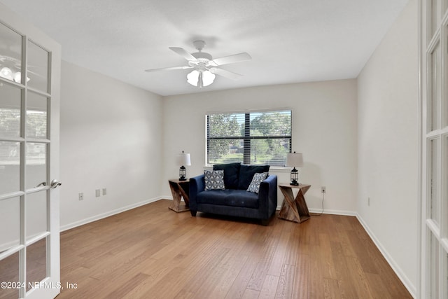 living area with ceiling fan and light wood-type flooring