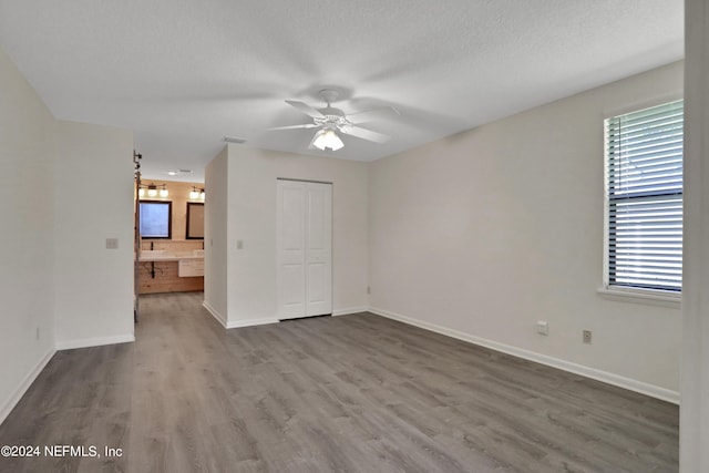 empty room featuring a textured ceiling, hardwood / wood-style floors, and ceiling fan