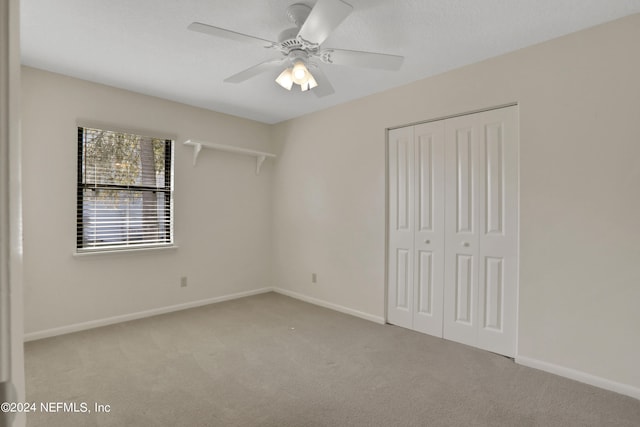 unfurnished bedroom with a closet, carpet, and ceiling fan