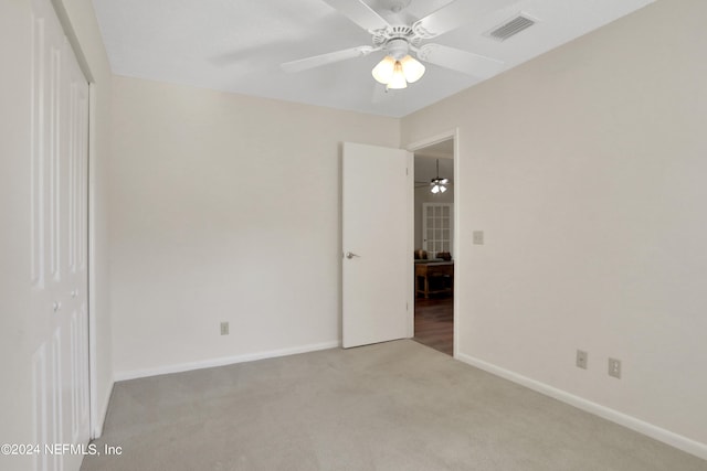 carpeted spare room with ceiling fan