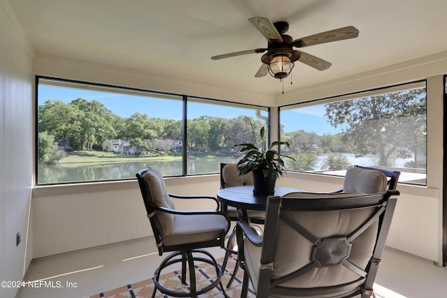 sunroom with a water view and ceiling fan