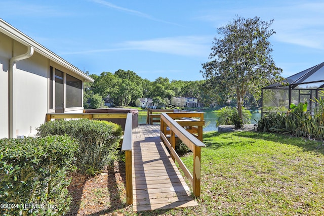 view of yard with a lanai and a water view