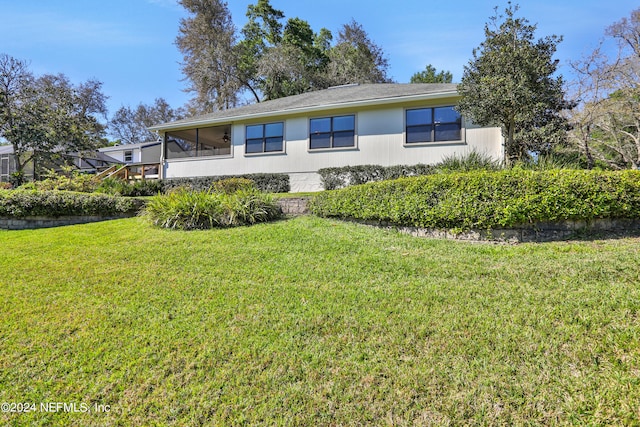 view of side of home with a yard