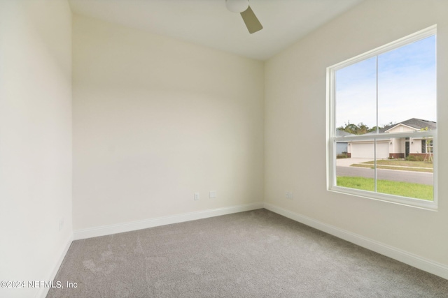 carpeted spare room featuring a wealth of natural light and ceiling fan