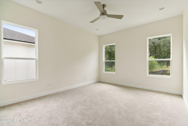 carpeted spare room with ceiling fan