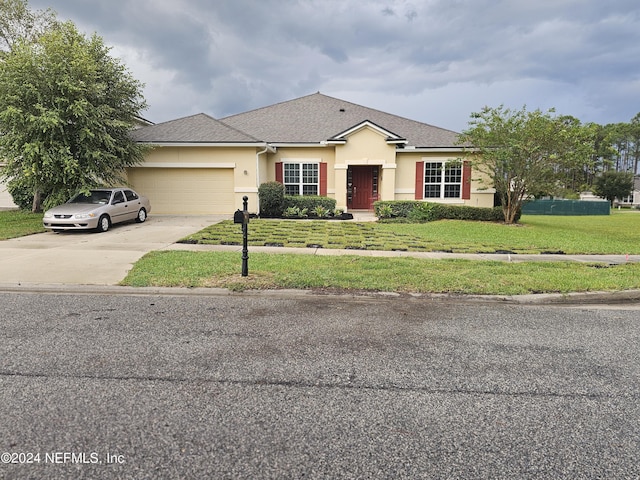 1075 Wetland Ridge Cir, Middleburg, FL 32068 - ranch-style house with an attached garage, concrete driveway, a front lawn, roof with shingles, and stucco siding