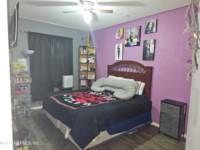 bedroom with ceiling fan, a textured ceiling, and dark hardwood / wood-style flooring