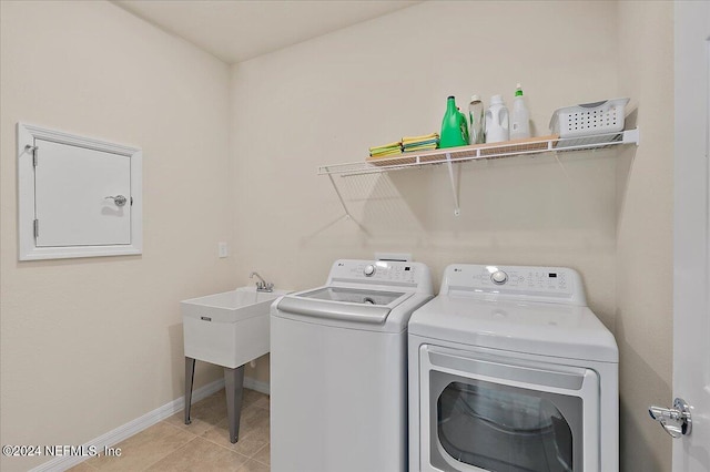 laundry room with washer and clothes dryer and light tile patterned flooring