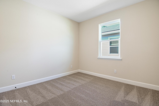 carpeted empty room with baseboards