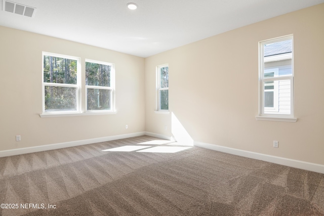 carpeted spare room with baseboards and visible vents