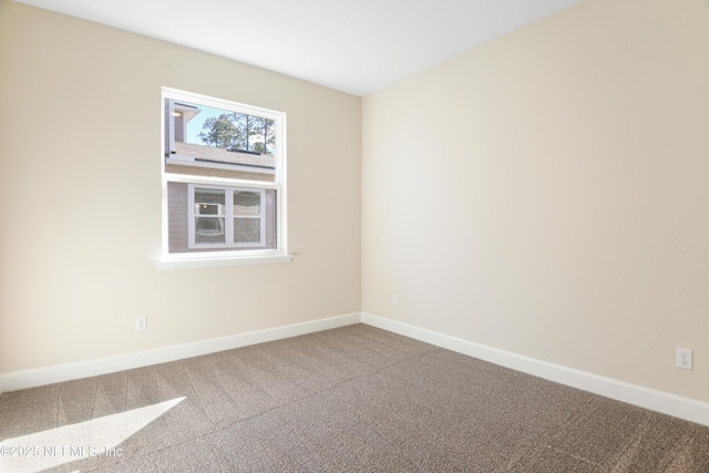 carpeted spare room featuring baseboards