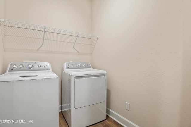 laundry area with laundry area, baseboards, wood finished floors, and independent washer and dryer