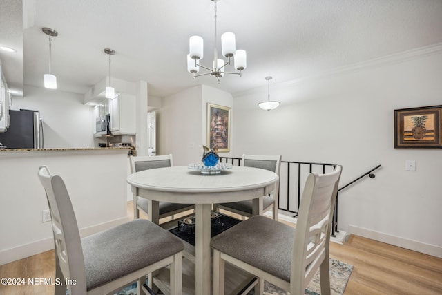 dining room with light hardwood / wood-style flooring and a chandelier