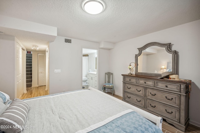 5375 Ortega Farms Blvd Unit 506, Jacksonville, FL 32210 - bedroom featuring visible vents, wood finished floors, a textured ceiling, and ensuite bathroom
