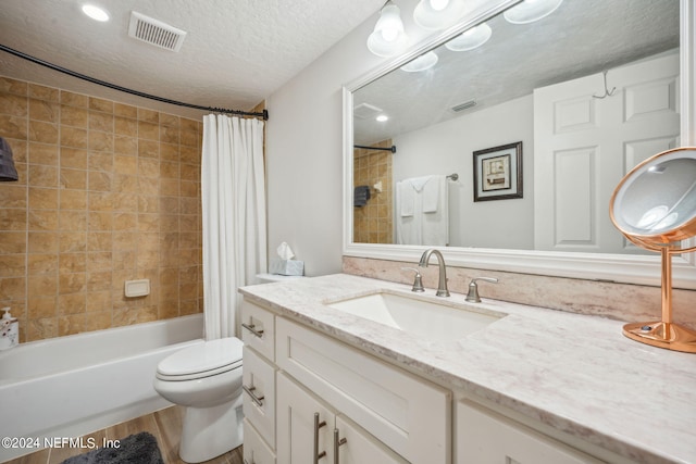 full bathroom featuring shower / bath combination with curtain, vanity, a textured ceiling, hardwood / wood-style flooring, and toilet