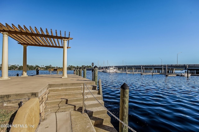 view of dock with a pergola and a water view