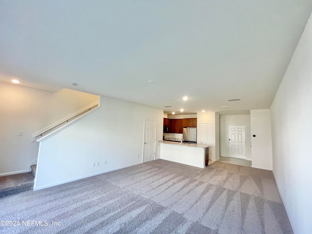 unfurnished living room featuring light carpet