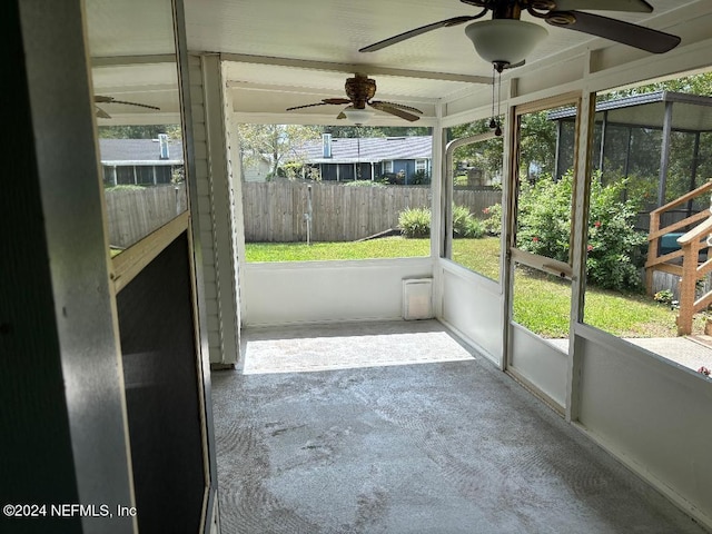 unfurnished sunroom featuring ceiling fan and plenty of natural light