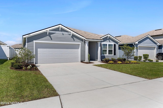 single story home with a garage and a front lawn