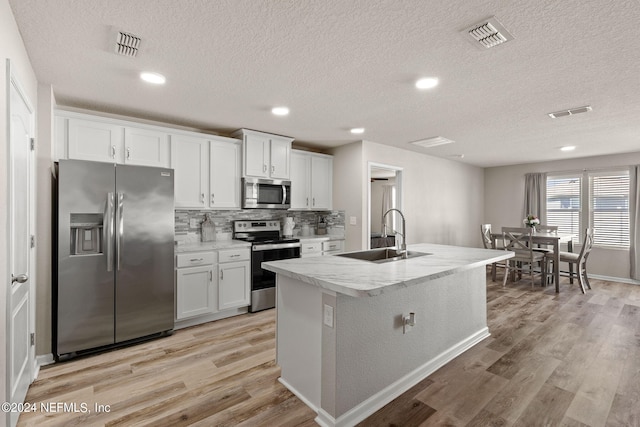 kitchen featuring light hardwood / wood-style flooring, white cabinetry, appliances with stainless steel finishes, and sink