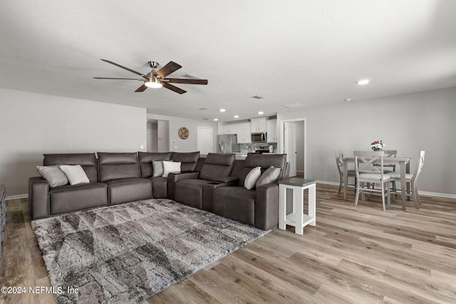 living room with ceiling fan and light wood-type flooring