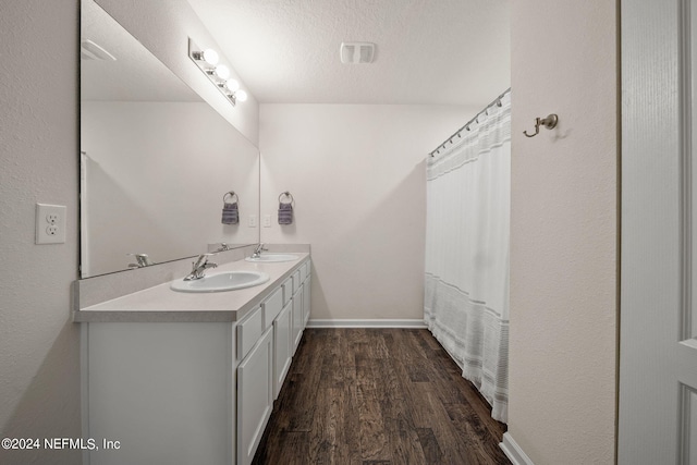 bathroom with a textured ceiling, vanity, a shower with shower curtain, and hardwood / wood-style flooring