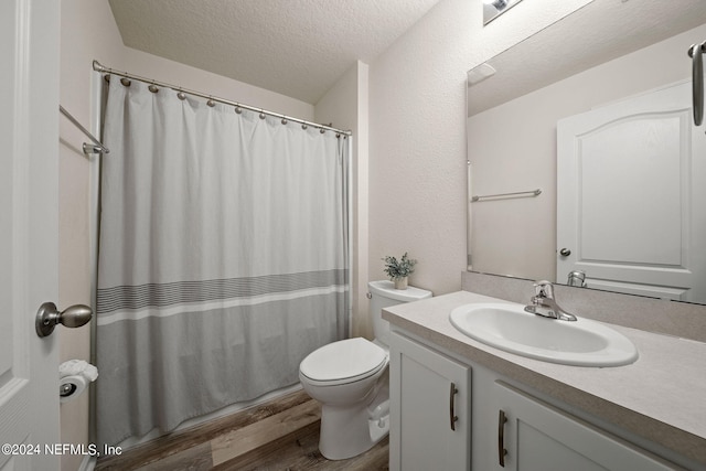 bathroom featuring vanity, a textured ceiling, wood-type flooring, a shower with shower curtain, and toilet