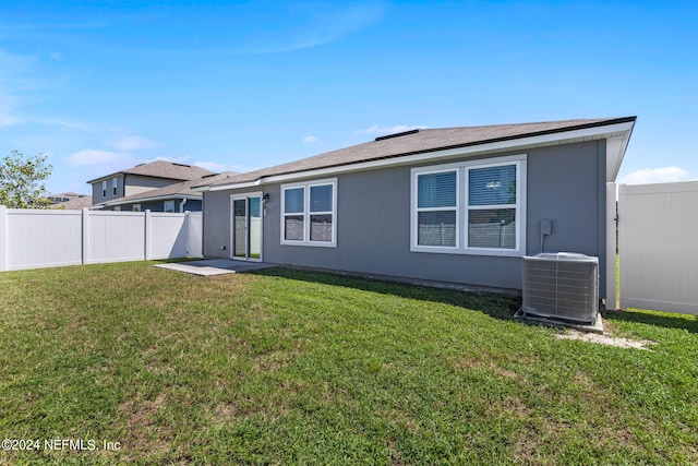 back of house with a yard and central AC unit