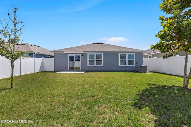 rear view of property with a patio, a yard, and central AC unit