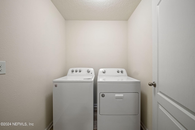 washroom with separate washer and dryer and a textured ceiling