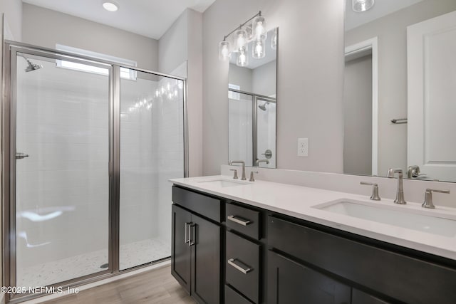 bathroom with vanity, a shower with shower door, and hardwood / wood-style floors