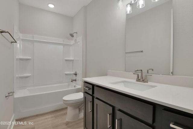 full bathroom featuring shower / washtub combination, toilet, wood-type flooring, and vanity