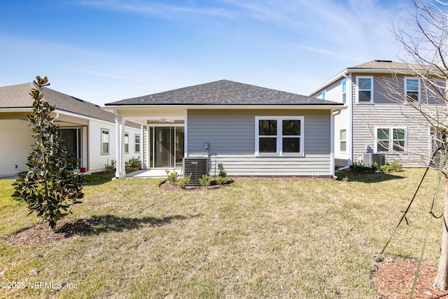 rear view of property featuring cooling unit, ceiling fan, and a yard