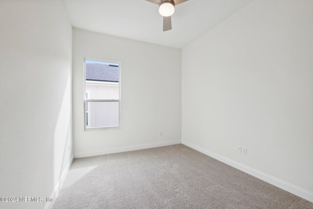 empty room with ceiling fan and light carpet