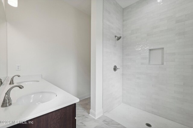 bathroom with vanity and tiled shower