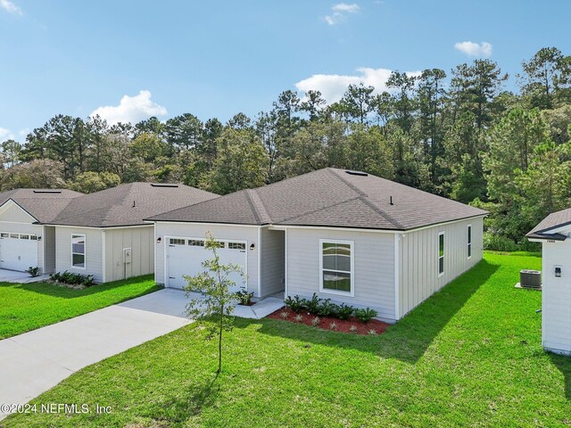 ranch-style home featuring a garage, central air condition unit, and a front lawn