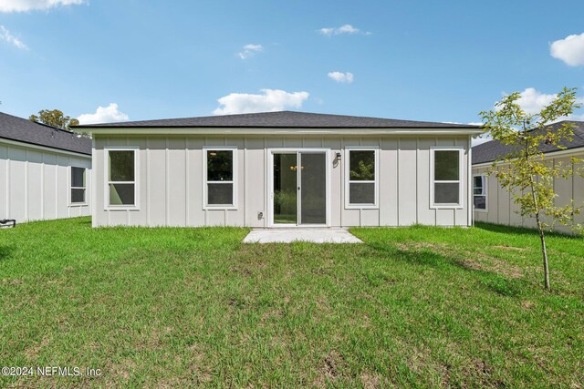 rear view of house featuring a lawn and a patio area