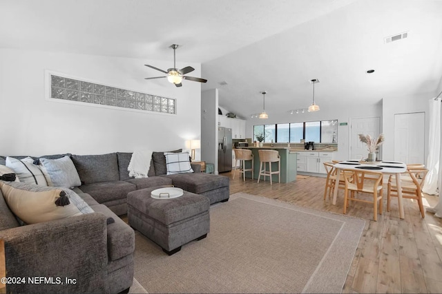 living room featuring light wood-type flooring, lofted ceiling, and ceiling fan