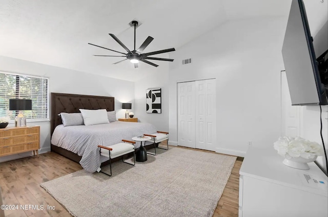 bedroom with a closet, wood-type flooring, lofted ceiling, and ceiling fan